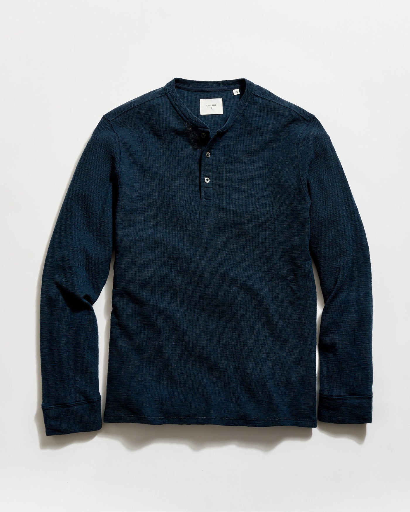 Navy long-sleeve henley shirt on a light gray background