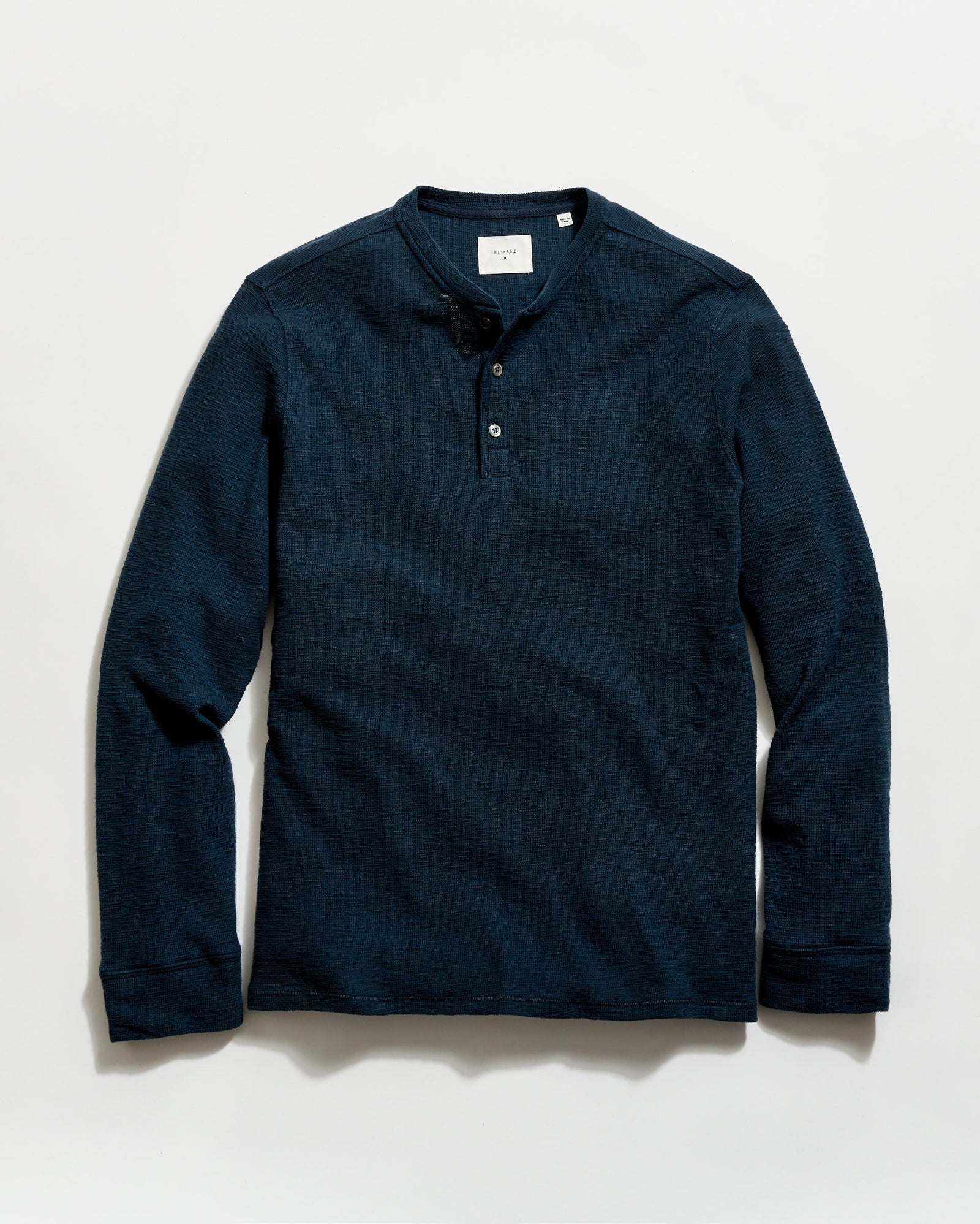 Navy long-sleeve henley shirt on a light gray background