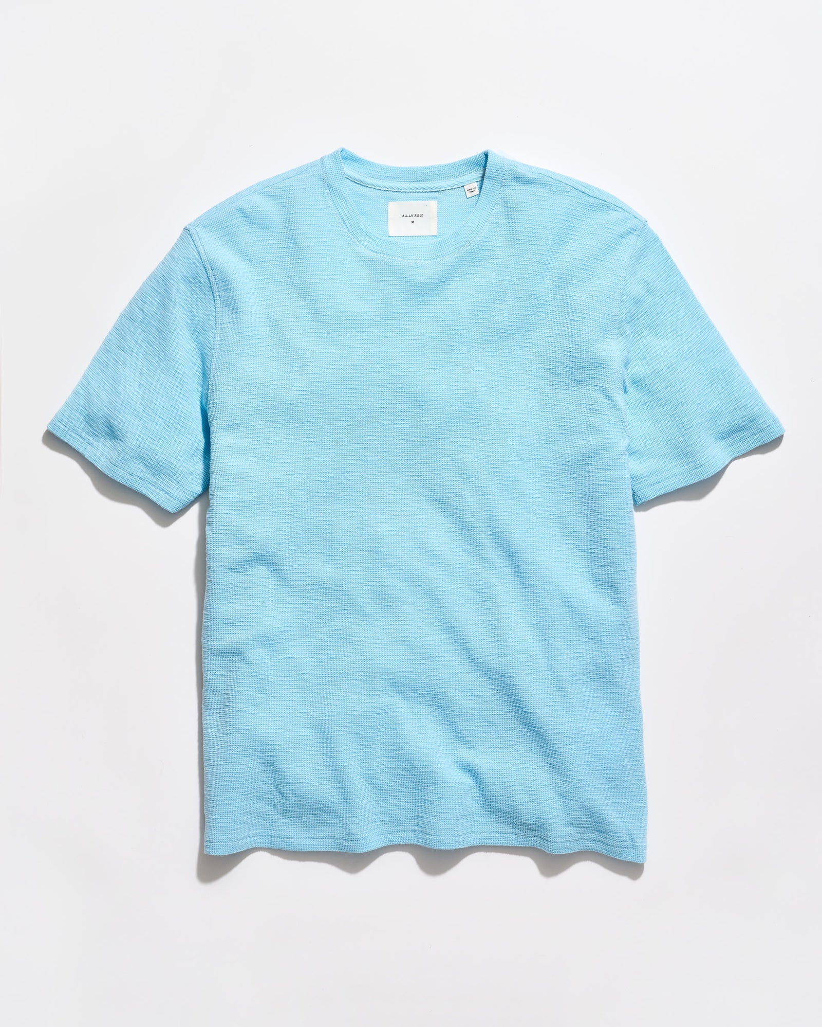 Light blue crew neck t-shirt on a grey background
