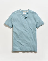 Blue henley shirt on a light gray background