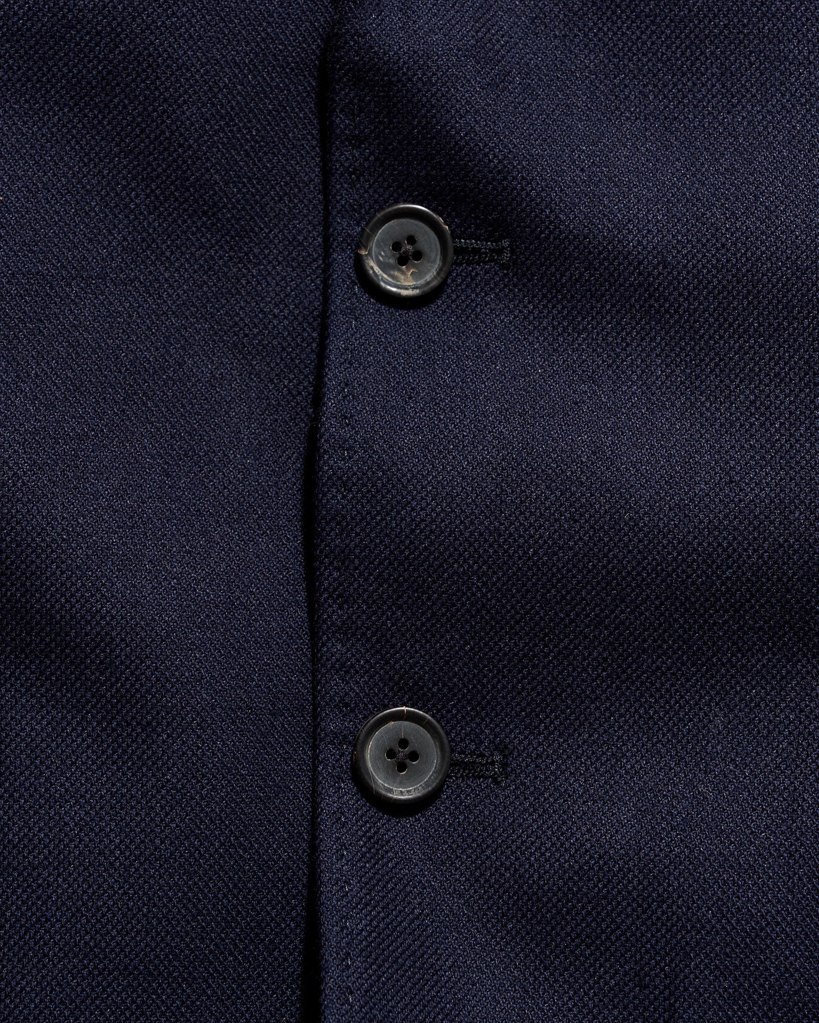 Close-up of a navy blue textured fabric with buttons