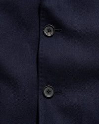 Close-up of a navy blue textured fabric with buttons