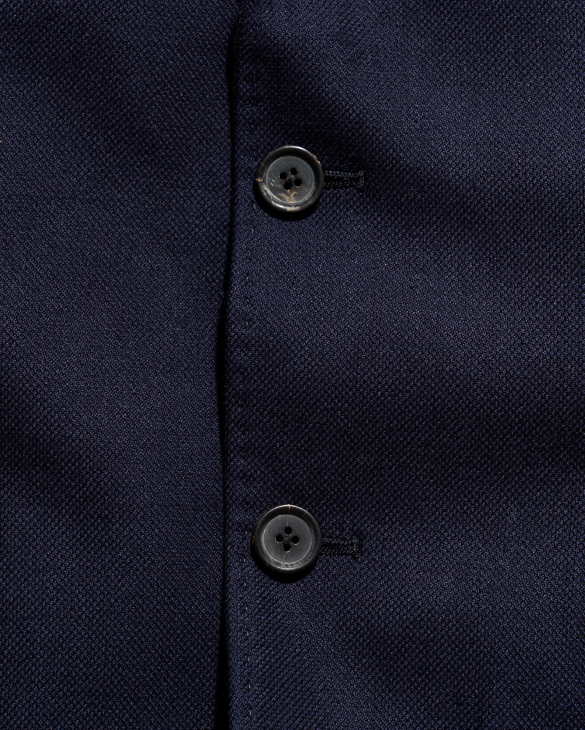 Close-up of a navy blue textured fabric with buttons