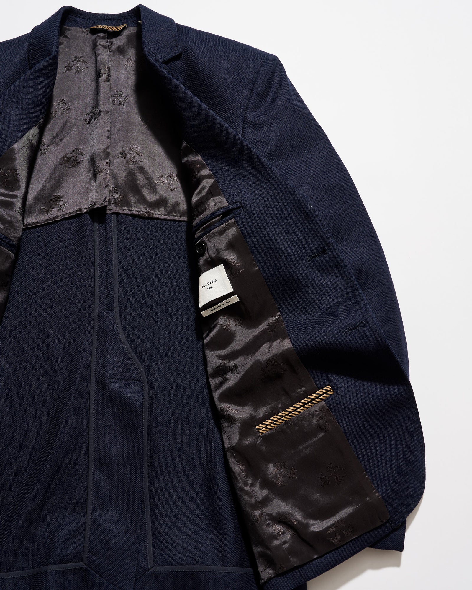 Navy blue suit jacket with satin lining on a white background