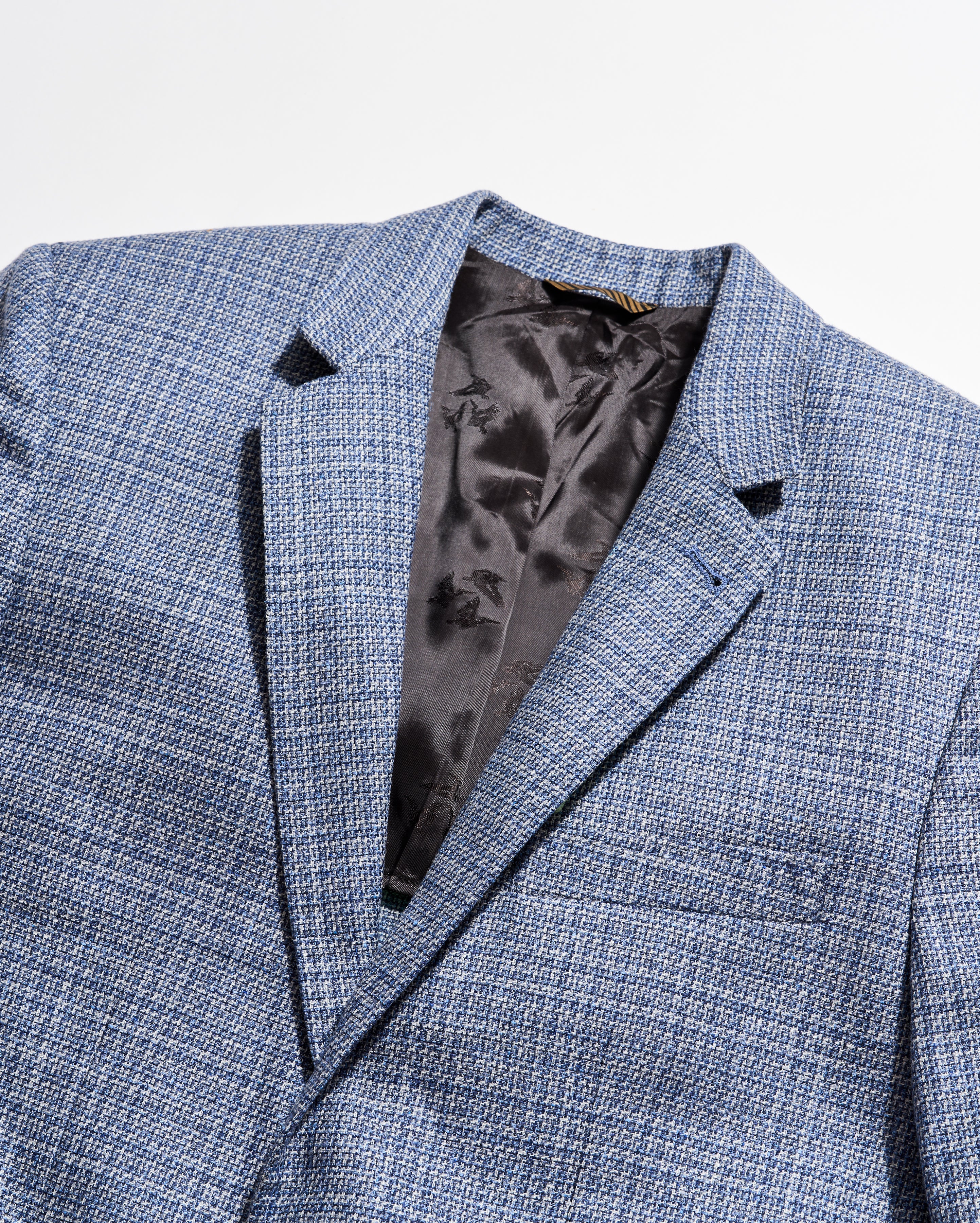 Blue checkered suit jacket with a satin lining on a light gray background