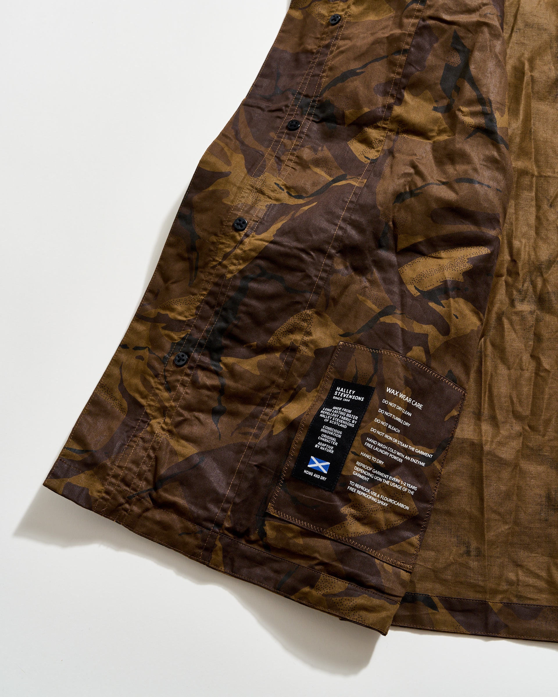 Brown camouflage pants with a brand label on a white background