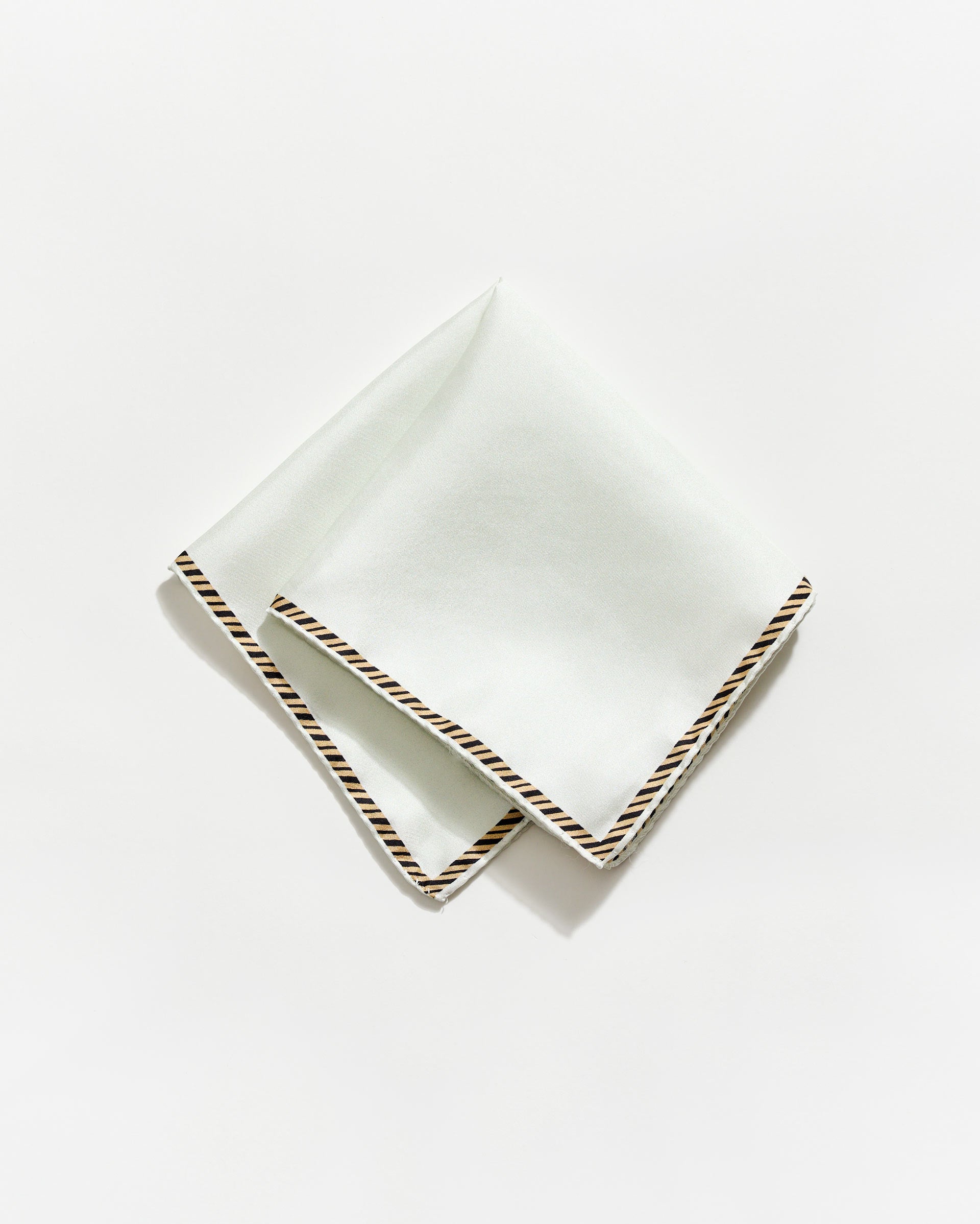 White napkin with gold trim on a white background