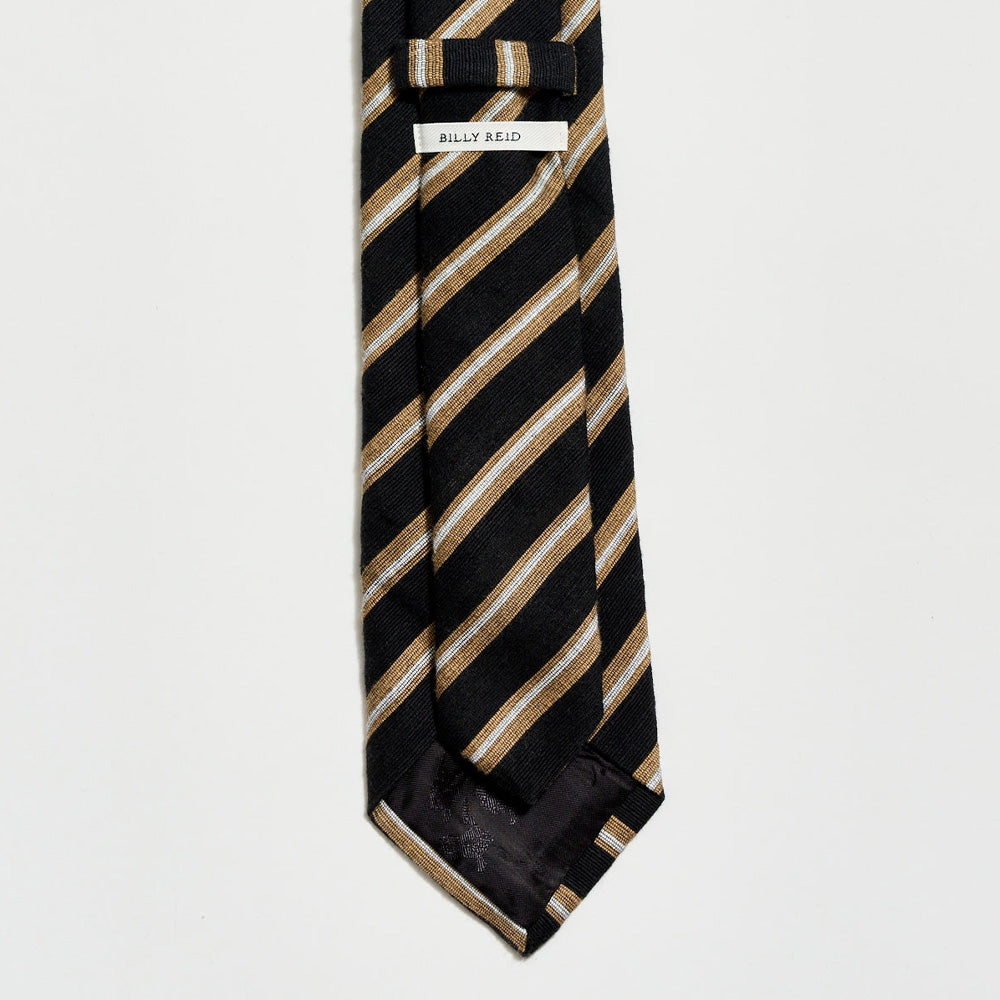 Black and gold striped tie with a label on a light gray background