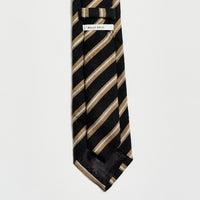 Black and gold striped tie with a label on a light gray background