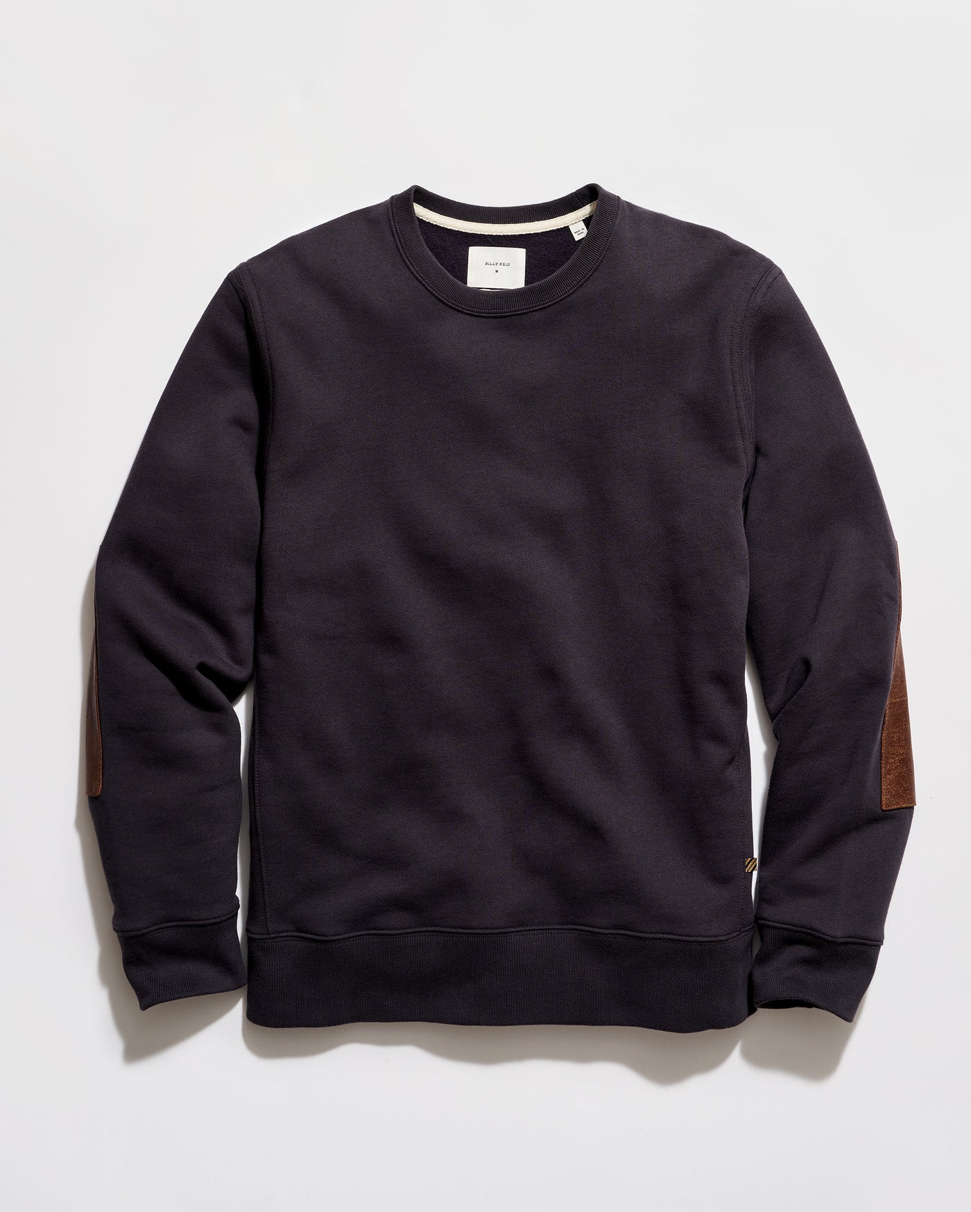 Black sweatshirt with brown elbow patches on a light gray background