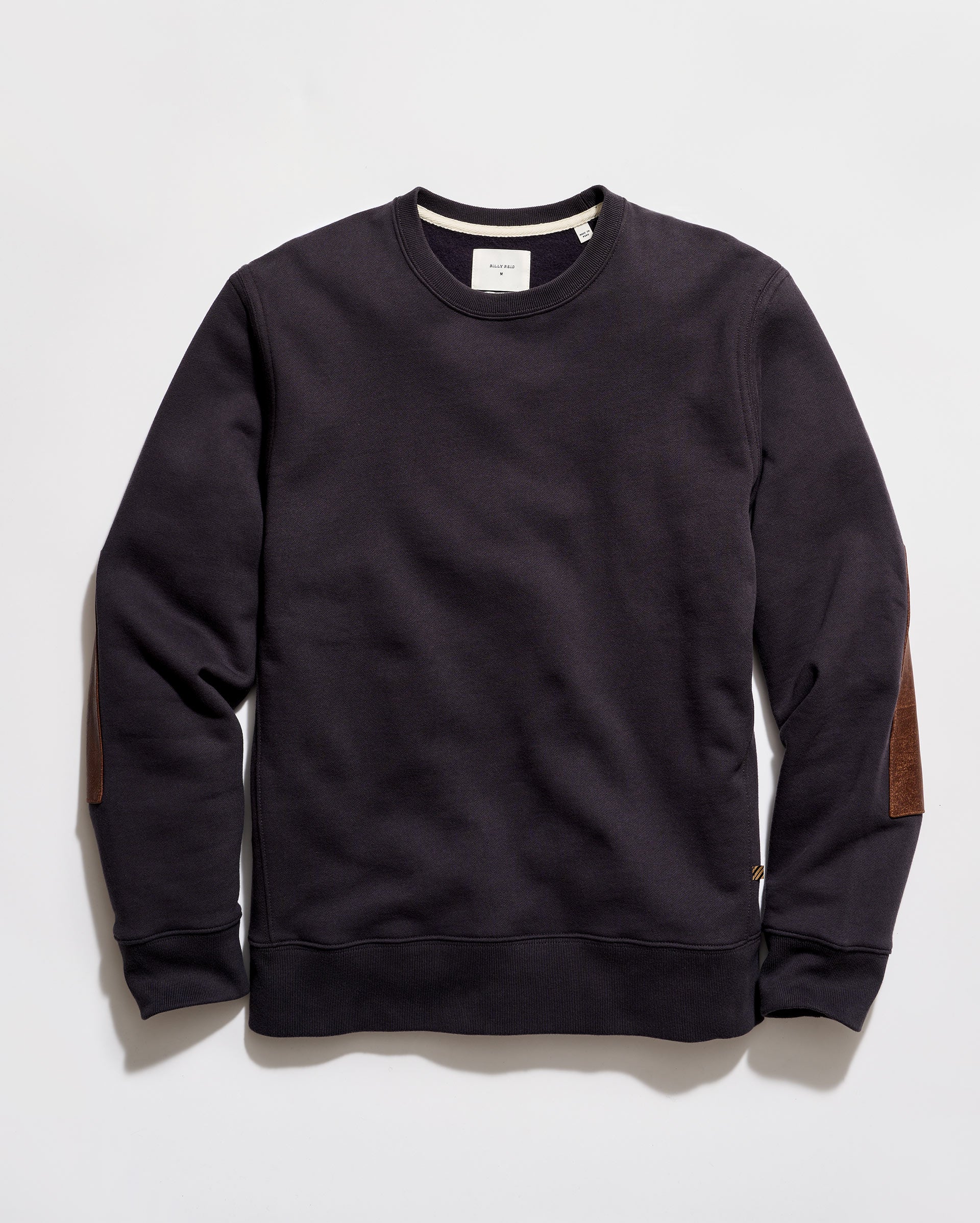 Black sweatshirt with brown elbow patches on a light gray background