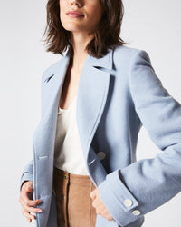 Female model wears the Macdougal Coat in Light Blue